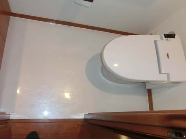 トイレの床に白い大理石調の塩ビタイルを施工した様子