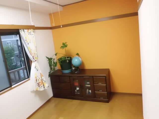 オレンジのアクセントクロスを取り入れて壁紙を貼り替えた部屋