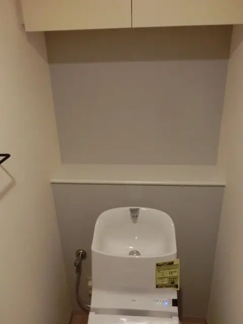 トイレに薄いグレーのアクセントクロスを取り入れた様子