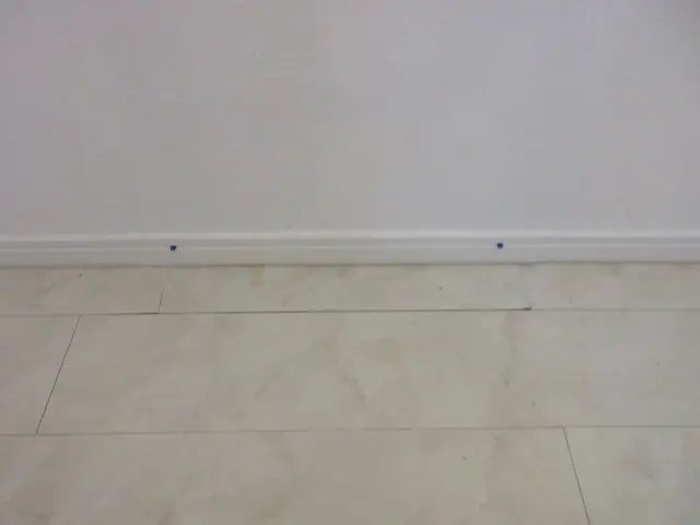 床材（塩ビタイル）を貼り戻し、木巾木を取り付けたら補修が終わりです。