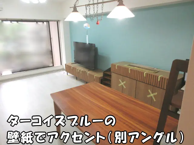リビングの壁一面をターコイズブルーの壁紙でアクセントにした様子（別アングル）